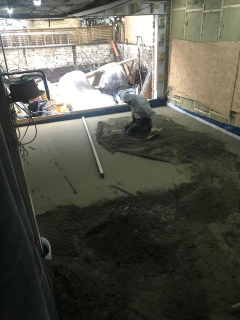 team member is doing basic cement screed London in basement